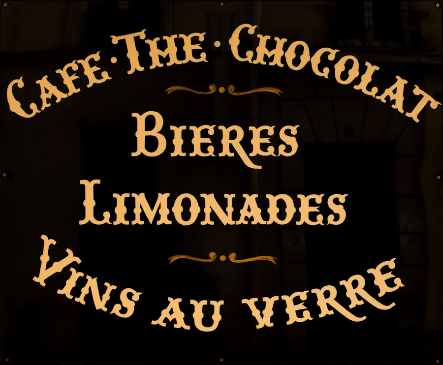 A french cafe sign advertises beverages.