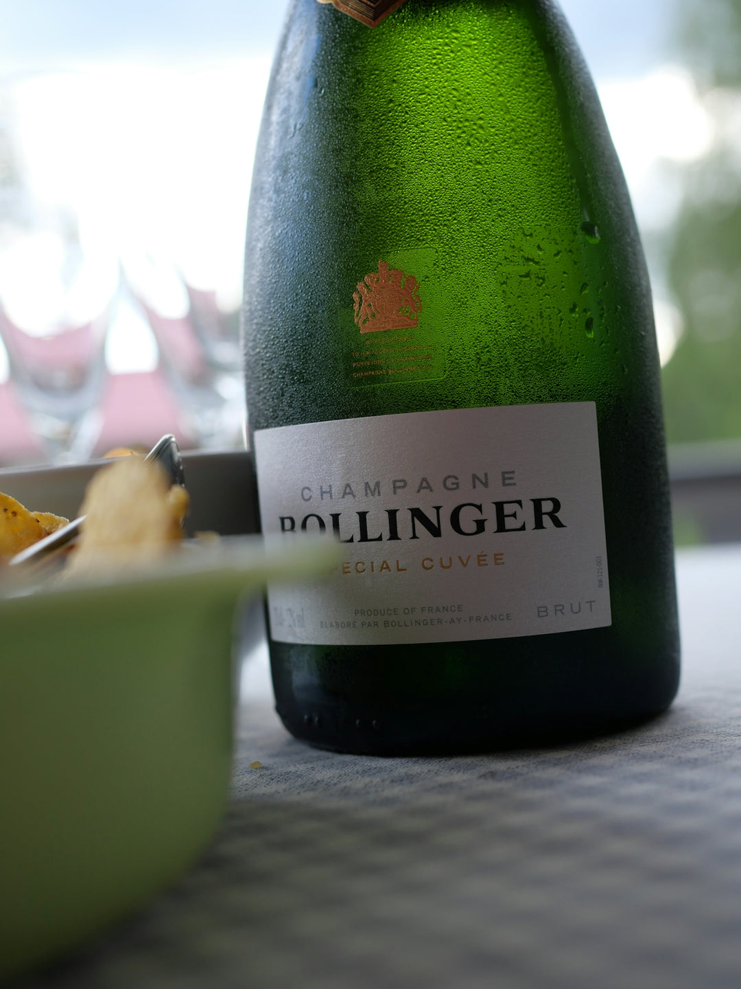 A bottle of bollinger champagne with condensation.